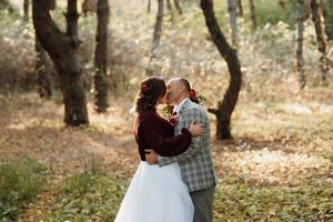 walk of the bride and groom through the autumn forest photo