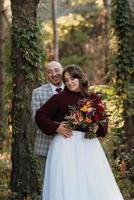 walk of the bride and groom through the autumn forest photo