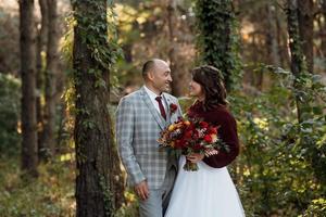 walk of the bride and groom through the autumn forest photo