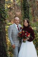 walk of the bride and groom through the autumn forest photo