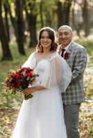 paseo de la novia y el novio por el bosque de otoño foto