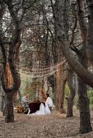 wedding dinner of a newlywed couple in the autumn forest photo