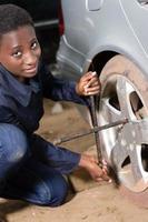 Auto mechanic removes the tire from a car. photo