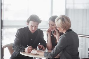 Team job succes. Photo young business managers working with new startup project in office. Analyze document, plans. Generic design notebook on wood table, papers, documents