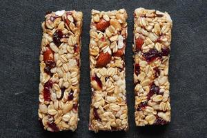 Almond , Raisin and oat protein bars on black background photo