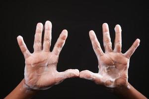 child boxy washing hands with soap isolated on black photo