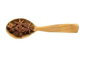 star anise in wooden spoon isolated on white background