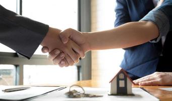 corredor de bienes raíces y cliente dándose la mano después de firmar un contrato de bienes raíces, préstamo hipotecario y concepto de seguro foto