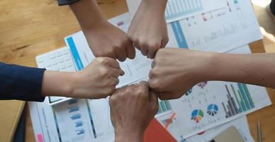 Cerrar vista superior de jóvenes empresarios juntando sus manos. pila de manos. concepto de unidad y trabajo en equipo. foto