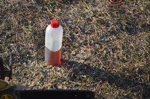 Machine oil stands on the grass for the saw photo