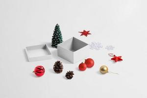 haciendo un hermoso regalo de navidad. Composición isométrica con caja y adornos navideños.