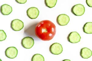 repeating pattern of sliced semicircles of fresh raw vegetable cucumbers for salad and tomato photo