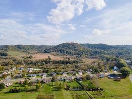 rural neighborhood and farm land in autumn in midwest mountains with trees and open landscape farm fields after harvest family friendly single-family homes and mobile home park for diversity. photo