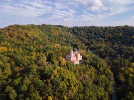 aerial view of shrine in forest on bluff during autumn in midwest on a sunny day church nestled in the trees on mountain beautiful blue sky photo