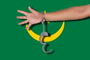 handcuffs with hand on Mauritania flag photo