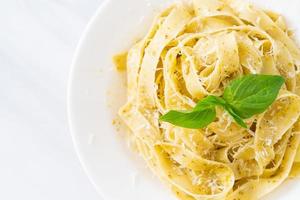 pasta fettuccine al pesto con queso parmesano encima foto