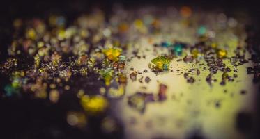 Colored diamonds scattered on a dark surface photo