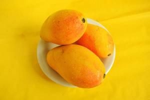 Fresh mango fruit on yellow background photo