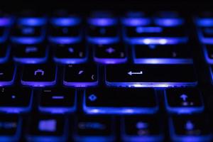 Closeup of laptop keyboard illumination, backlit keyboard. Blue light photo