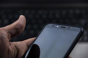hand of senior person using a modern mobile in a workspace photo