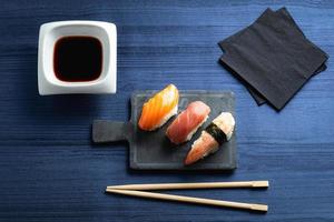 Elegant sushi on wood table. Some Nigiri, with soy sauce and chopstick photo
