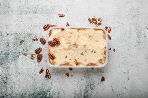 ice cream with ground nuts on white concrete table photo