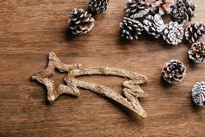 Pine cones and Christmas shooting star on wood background. Christmas decoration photo
