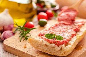 rustic bread, tomato and olive oil ready to make toasts photo