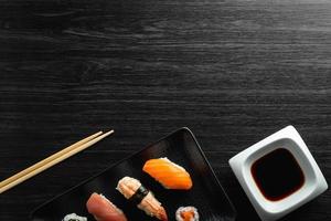 Elegant sushi on wood table. Some Nigiri, with soy sauce and chopstick photo