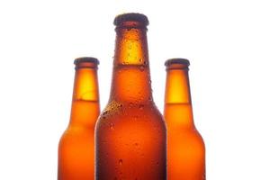 Three fresh beer bottle with big water drops on white background photo