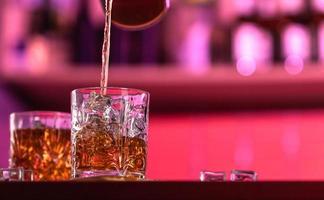 Bebidas de whisky con hielo en un bar salón. foto