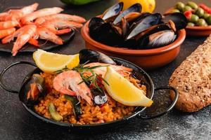 Paella de comida tradicional española, servida en un plato de tapa foto