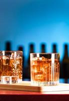 Vasos de whisky con hielo en un bar salón. foto