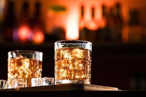 Vasos de whisky con hielo en un bar salón. foto