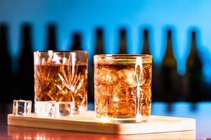 Whiskey glasses with ice in a lounge bar photo