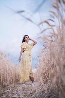 joven despreocupada disfrutando de la naturaleza mientras posa en un campo de trigo. foto