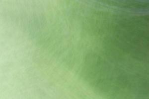 A gradient from a light green background with circular highlights, spots and scratches. photo