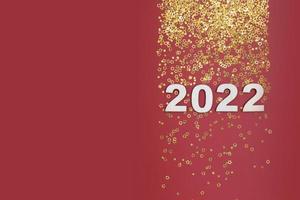 New year 2022 numbers on red background with golden stars copy space photo