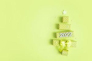 Tarjeta de felicitación con árbol de navidad abstracto hecho de cajas de regalo y números 2022 para feliz navidad y año nuevo foto