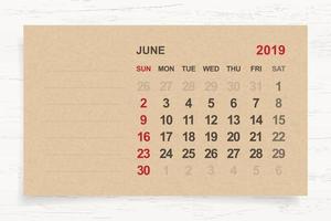 June 2019 - Monthly calendar on brown paper and wood background with area for note. Vector. vector