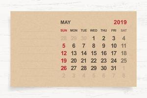 May 2019 - Monthly calendar on brown paper and wood background with area for note. Vector. vector