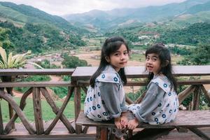 Happy smiling family enjoying  sitting on balcony and looking at mountains and green photo