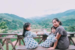 Happy smiling family enjoying  sitting on balcony and looking at mountains and green photo