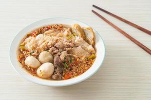 noodles with pork and meatballs in spicy soup photo