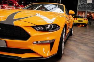 SINSHEIM, GERMANY - OCTOBER 16, 2018 Technik Museum. Two cars. Gorgeous close up view of the front of luxury yellow automobile standing indoors photo