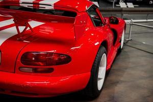 SINSHEIM, GERMANY - OCTOBER 16, 2018 Technik Museum. Amazing red sport car with white stripes parked indoors. Cropped photo