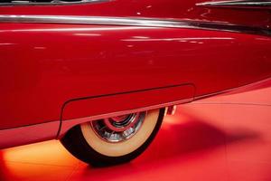 SINSHEIM, GERMANY - OCTOBER 16, 2018 Technik Museum. Close up photo. Side part of the red vintage car. Rear creamy colored wheel photo