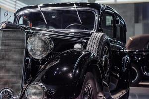 STUTTGART, GERMANY - OCTOBER 16, 2018 Mercedes Museum. Polished black retro car with spare wheel at the side parked indoors photo