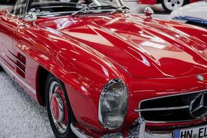 SINSHEIM, GERMANY - OCTOBER 16, 2018 Technik Museum. Perfectly polished red classic car with other vehicles behind photo