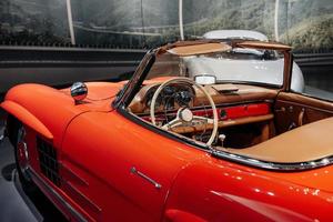 Inside of vintage red shiny car standing indoor at automobile exhibition photo